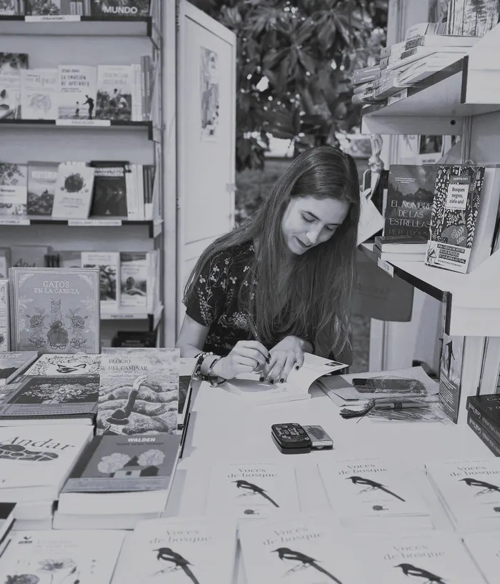 Fotografía en blanco y negro de la autora Virginia Marín firmando ejemplares de sus libros en la Feria del Libro de Madrid